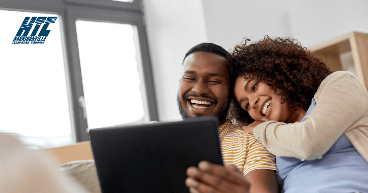A couple looking at a tablet together while reviewing service plans with HTC