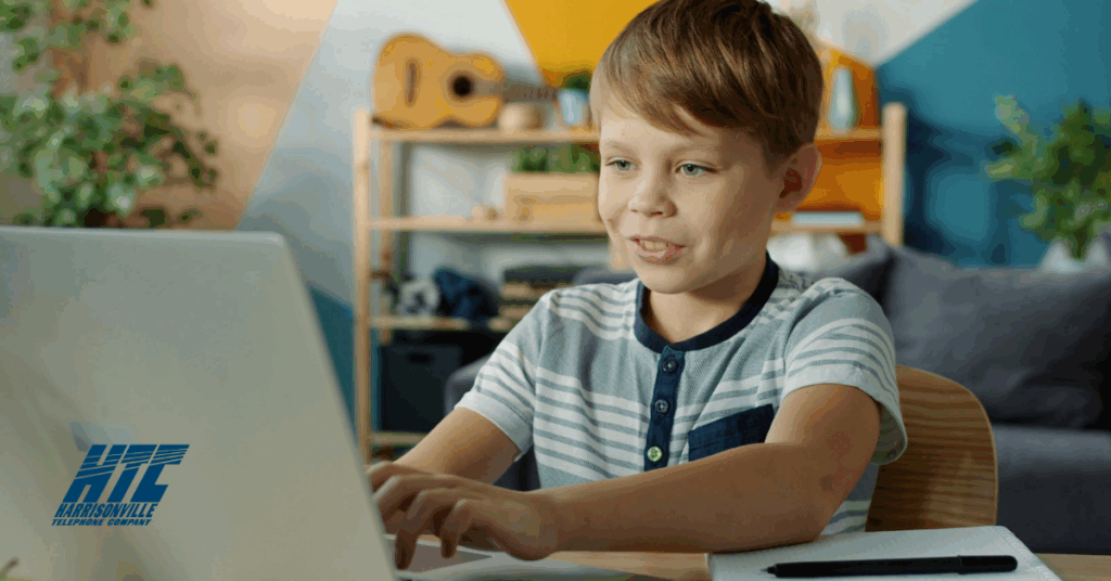 Young child sits at a computer at home to get ready for learning this school year