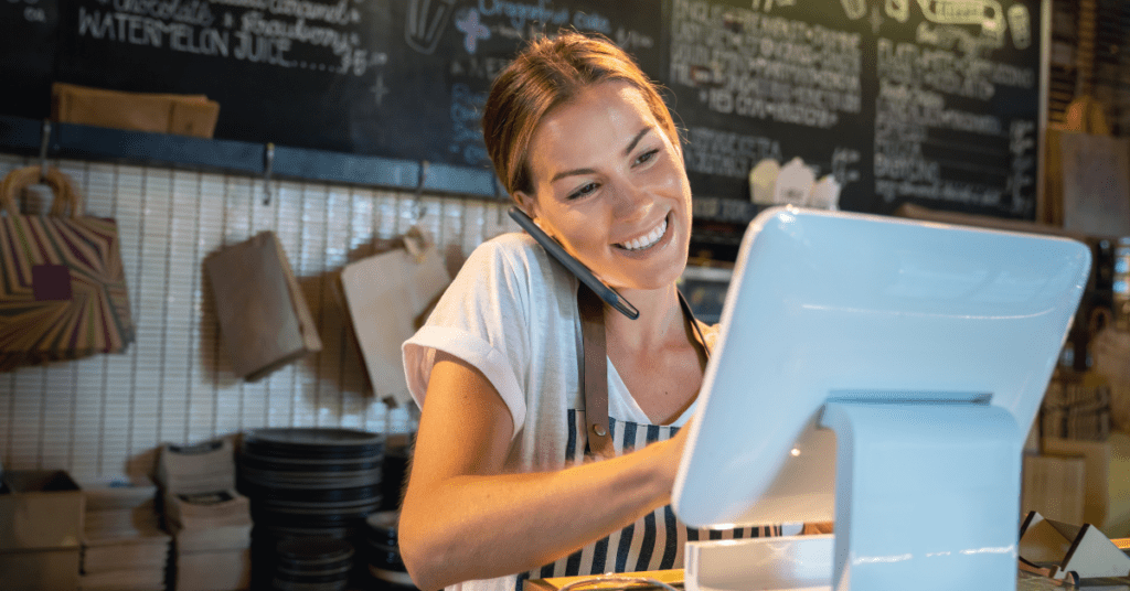 Young woman uses business phone and Internet solutions to place an order at the cafe.
