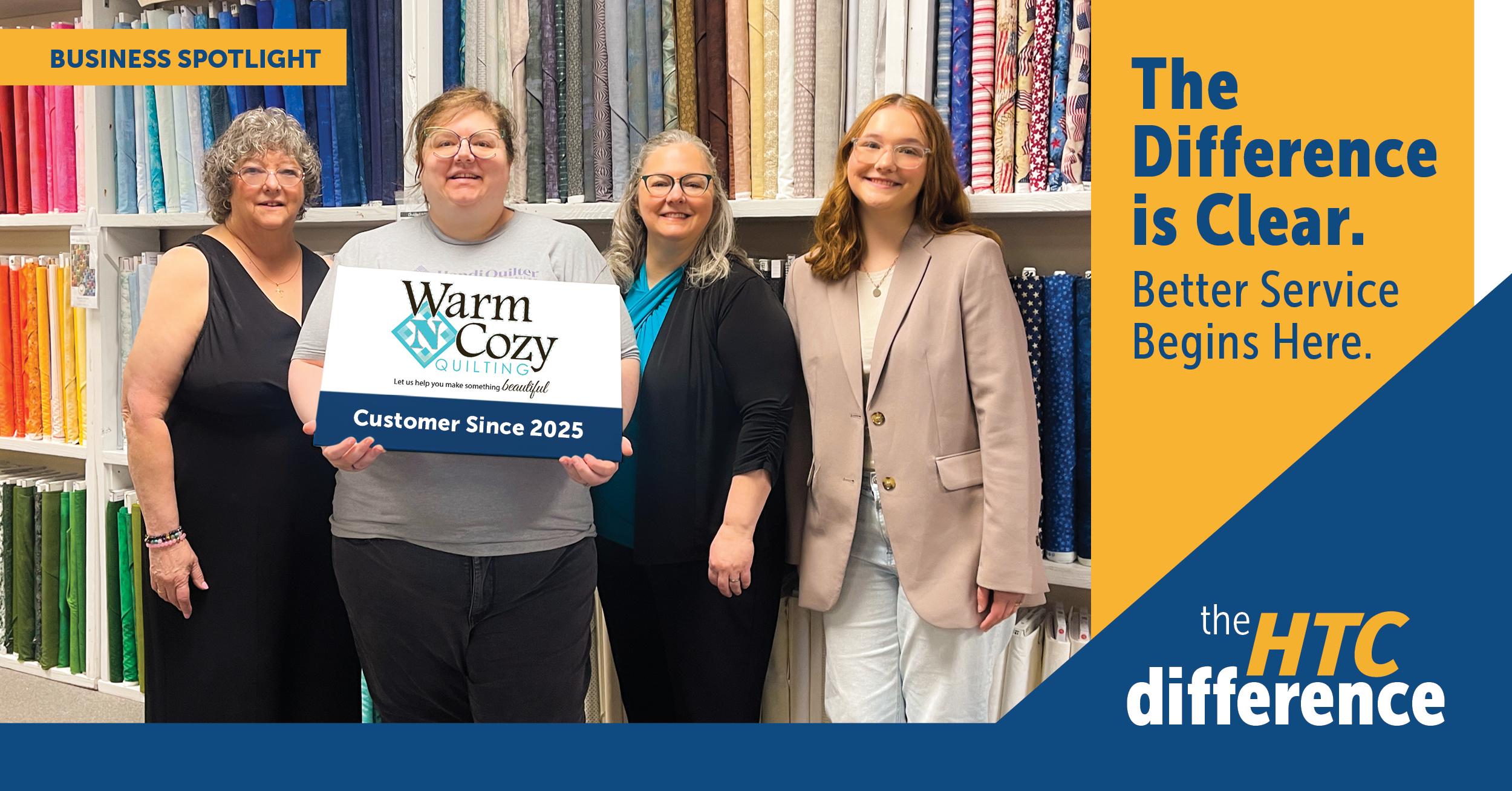 HTC_Blog Graphics_Warm_N_Cozy Blog header graphic featuring picture of Warm N Cozy Quilting owners and employees, plus the HTC logo and the words "Business Spotlight" and "The Difference is Clear"