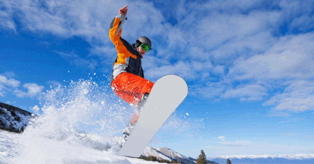 Person riding on a snowboard in the snow as part of winter sports