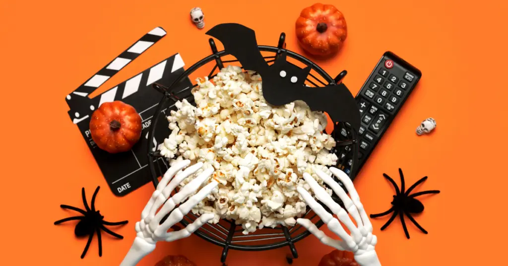 Blog header images for Watch Halloween Movies with HTC TV Now featuring an orange background, popcorn, and fake skeleton hands in the popcorn bowl.